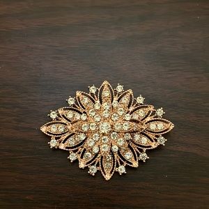Rose gold and rhinestone brooch.